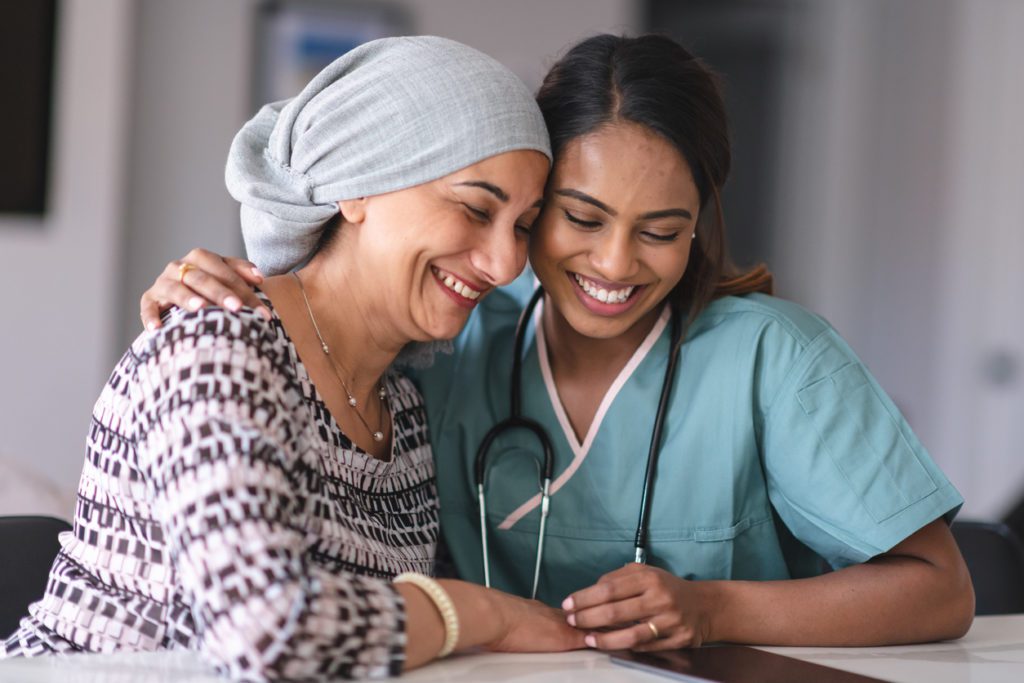 A patient being hugged by an oncologist at the cancer treatment center before her breast cancer surgery radiation treatment.