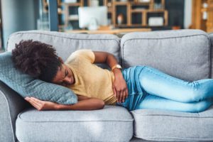 Woman laying on the couch with abdominal pain