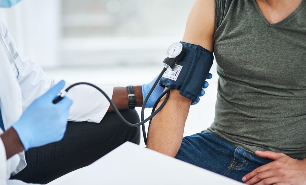 A woman getting her blood pressure checked to see if it is high.