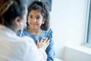 Family Doctor Listening to a Young Girls Heart