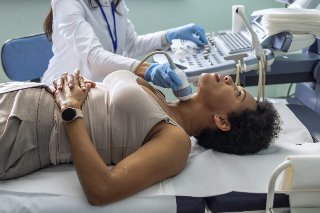 Endocrinologist doing ultrasound of thyroid gland on a female patient