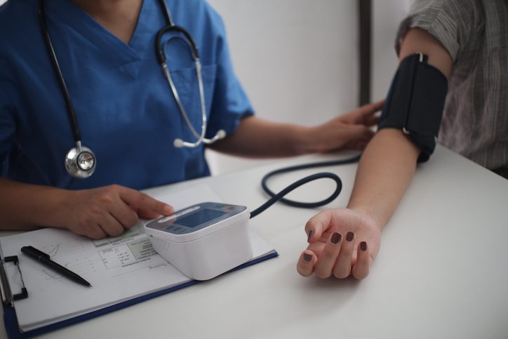 Nurse measuring blood pressure of a patient at primary care center