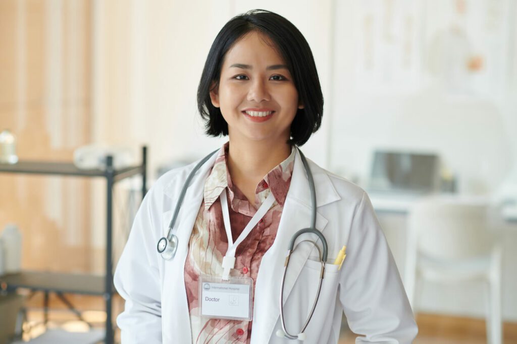 A picture of a smiling female primary care physician who helps patients with chronic conditions.