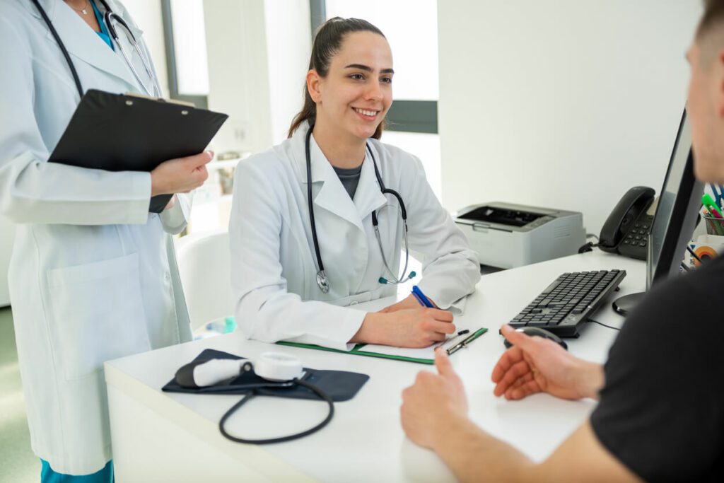 A compassionate primary care doctor discusses treatment options with a patient in the clinic.