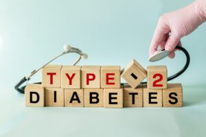 Type 2 diabetes, written on wooden blocks, with a hand holding a stethoscope.