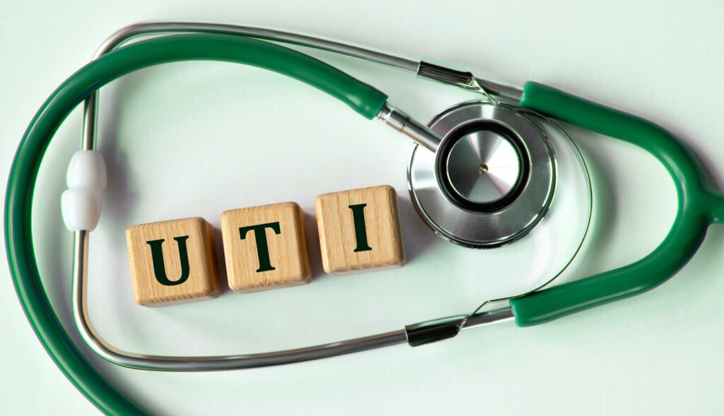 Cubes with the abbreviation UTI (urinary tract infection) on the background of a stethoscope.